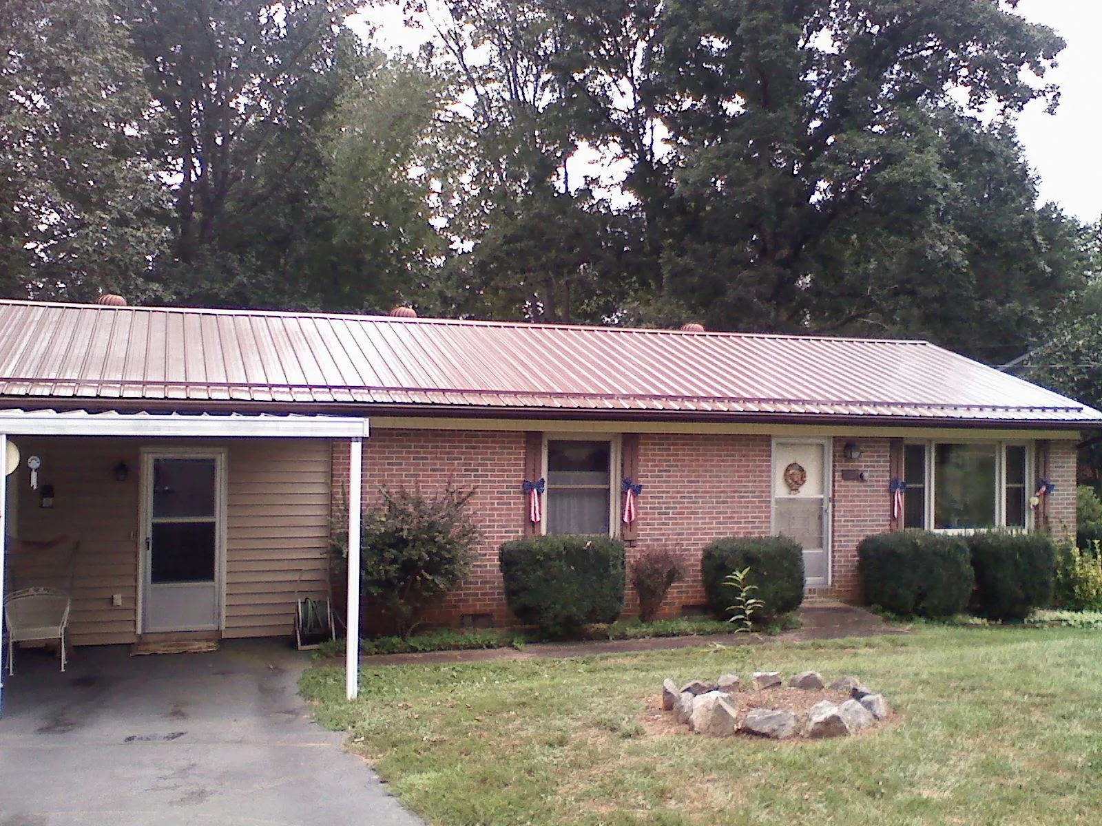 Bronze metal roof and carport on a brick ranch home — Roof Repair work by our crew in Saratoga Springs